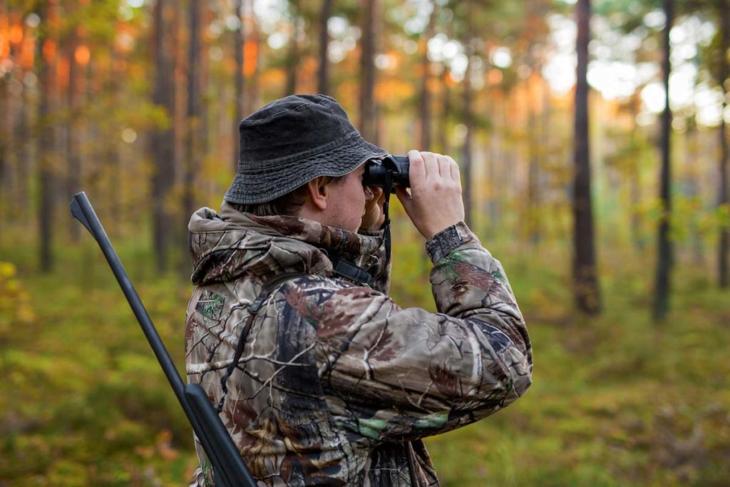 Chasseur utilisant des jumelles de chasse pour repérer sa proie